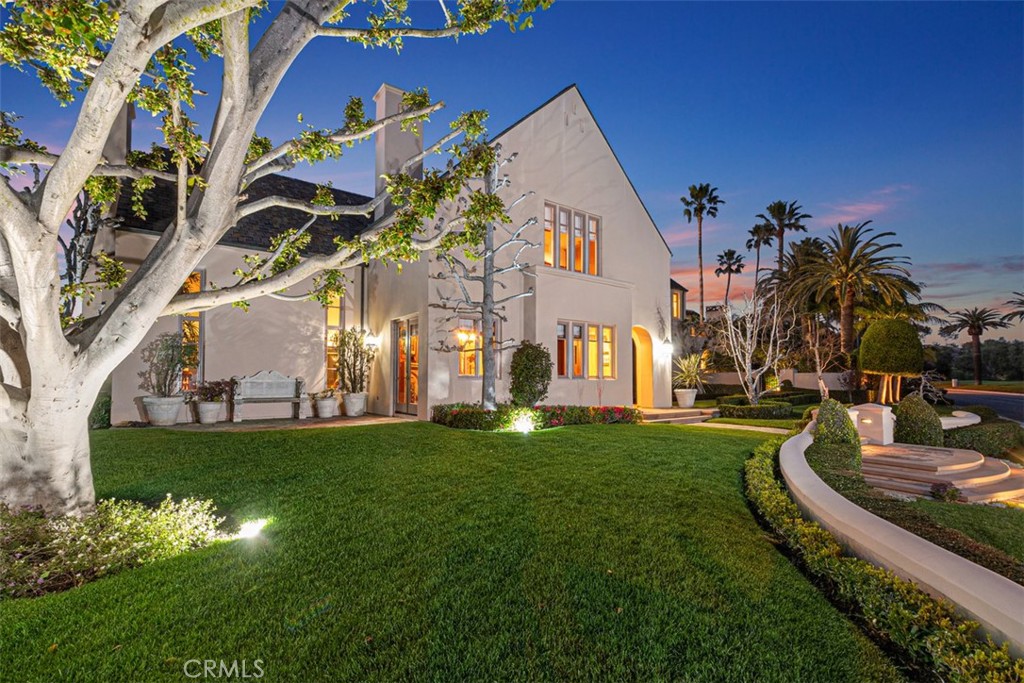 a view of a house with a big yard potted plants and large tree