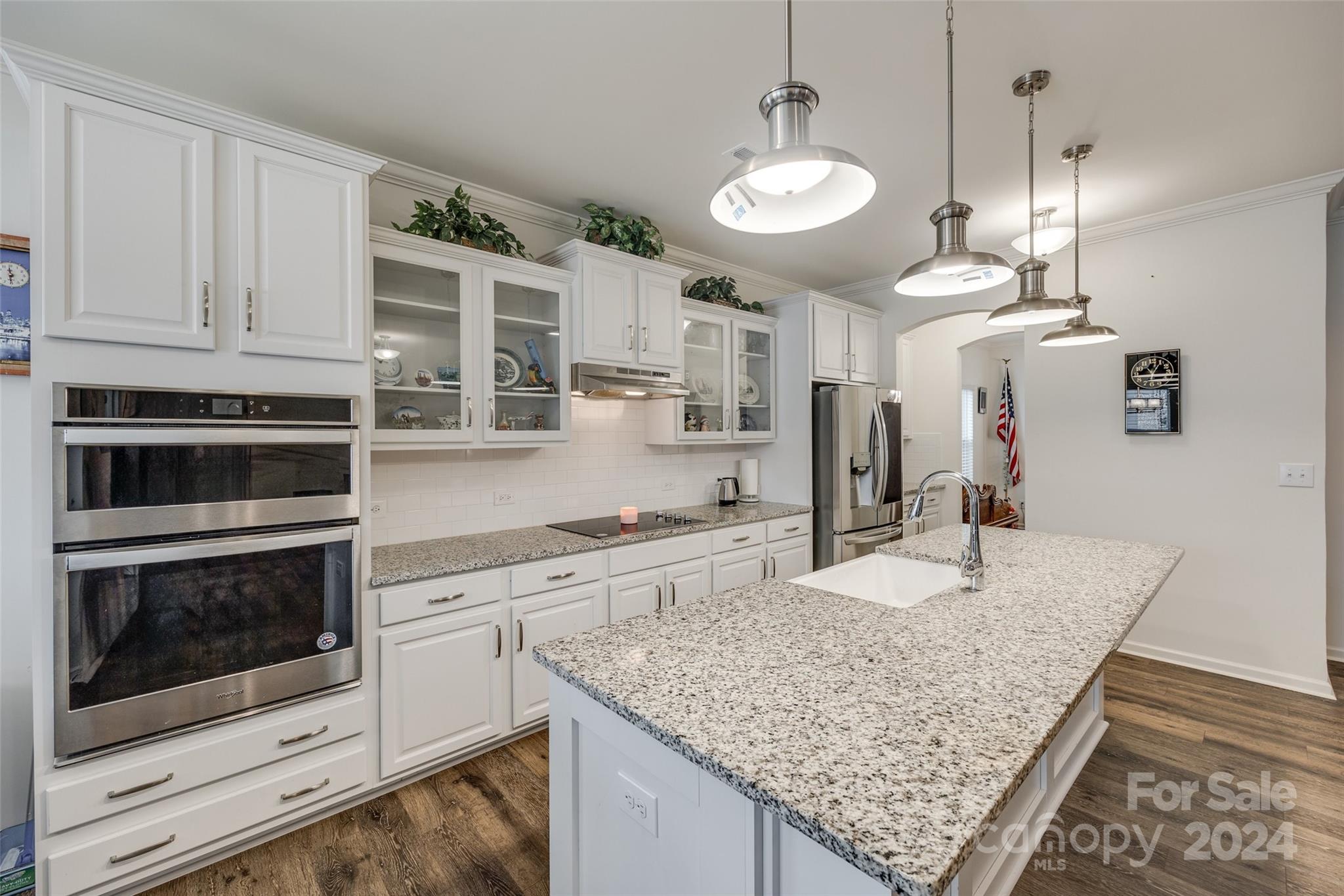 a kitchen with stainless steel appliances granite countertop a stove oven and a white cabinets