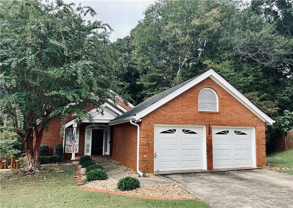 a front view of house with yard and trees in the background