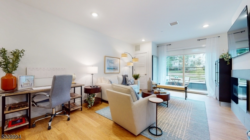 a living room with furniture a window and a flat screen tv