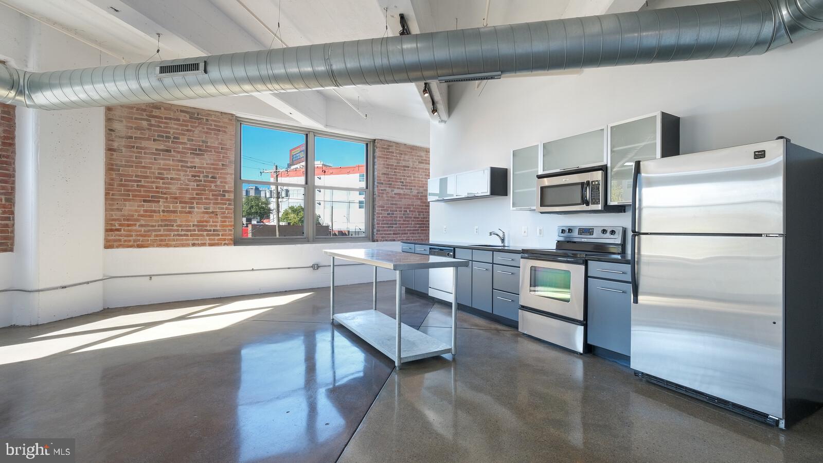 a kitchen with a refrigerator and a stove top oven