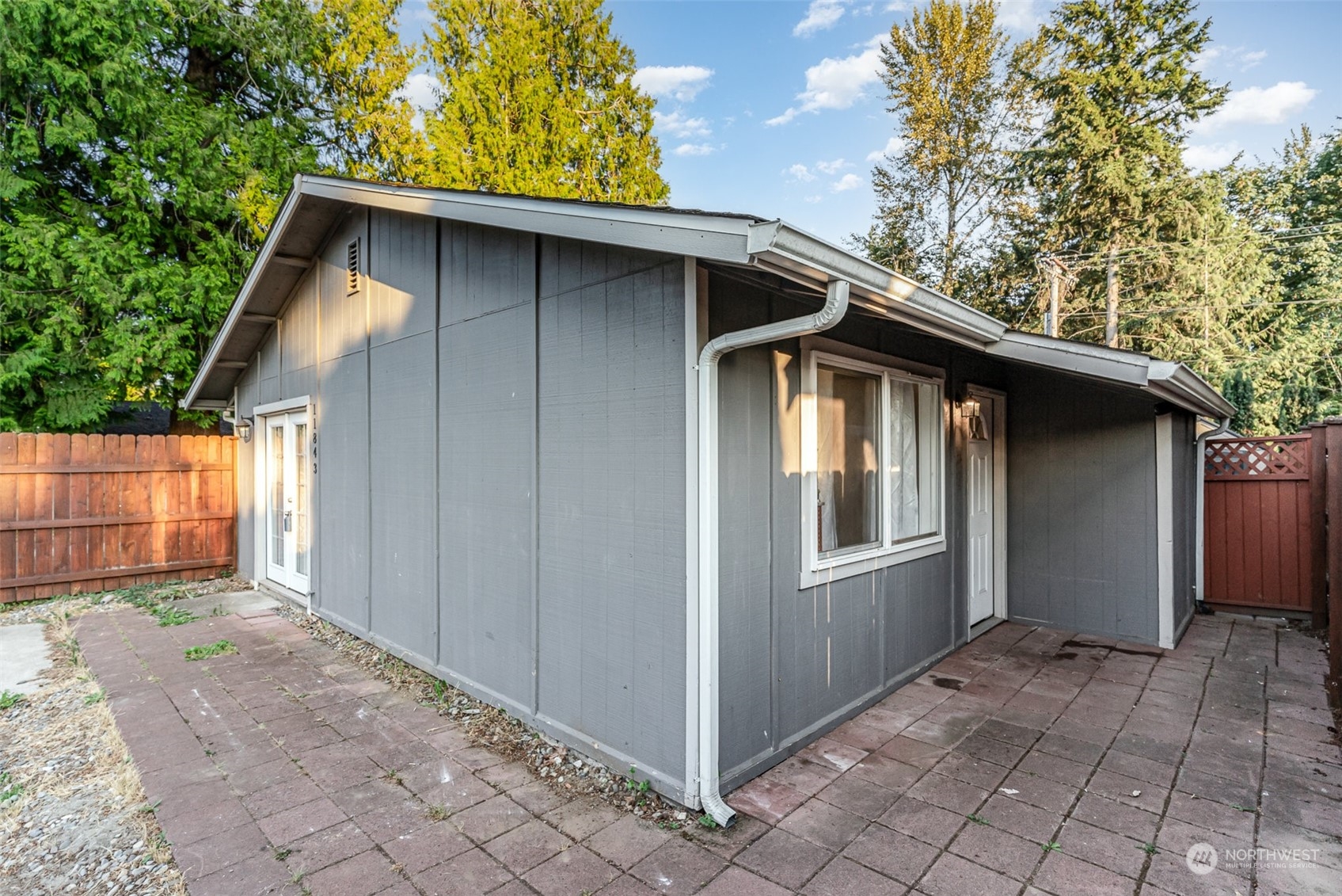 a view of backyard of house with wooden fence