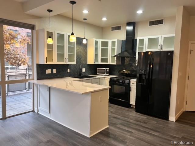 a kitchen with stainless steel appliances granite countertop a stove a refrigerator a sink and a oven with wooden floor