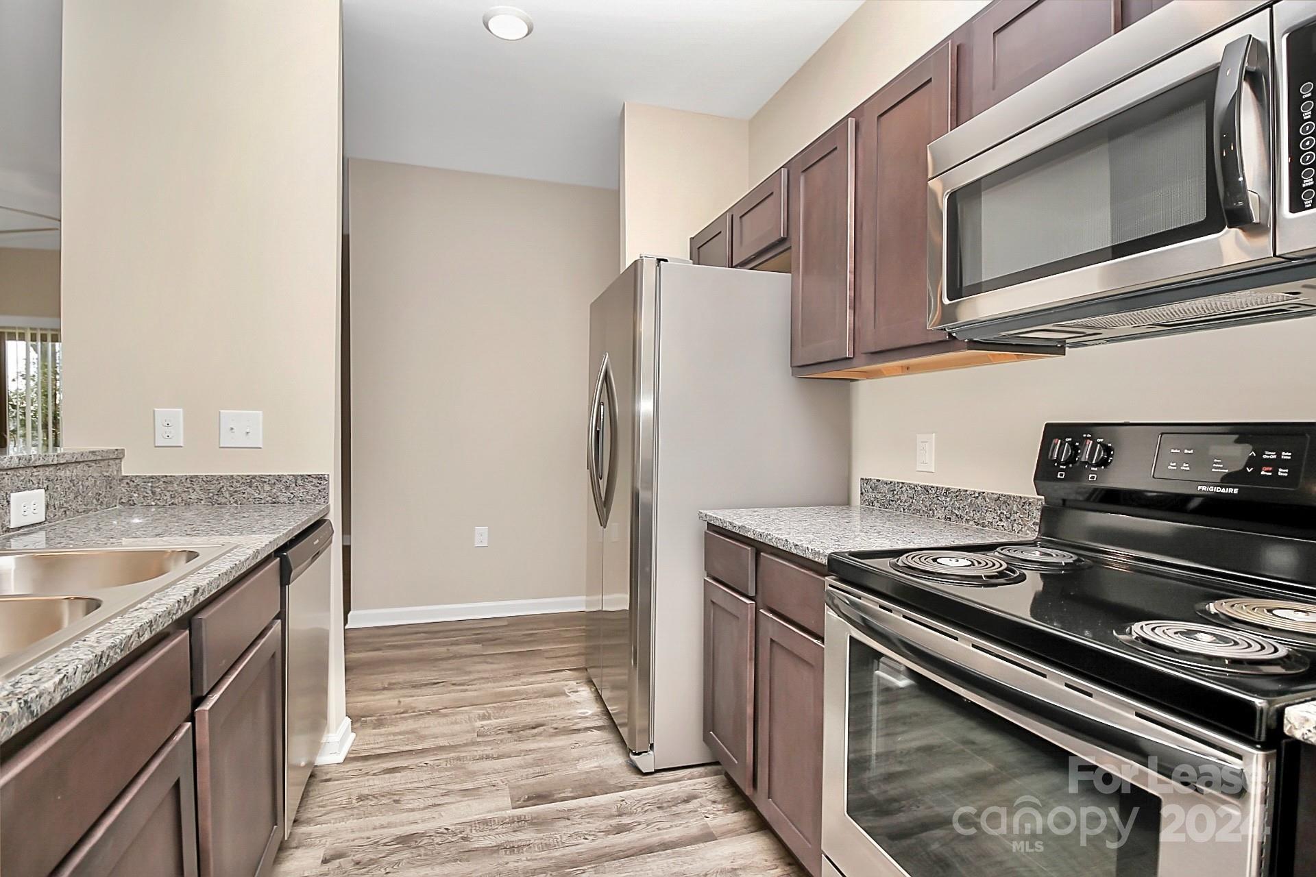 a kitchen with stainless steel appliances granite countertop a stove and a refrigerator