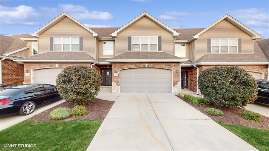 a front view of a house with a garden and parking