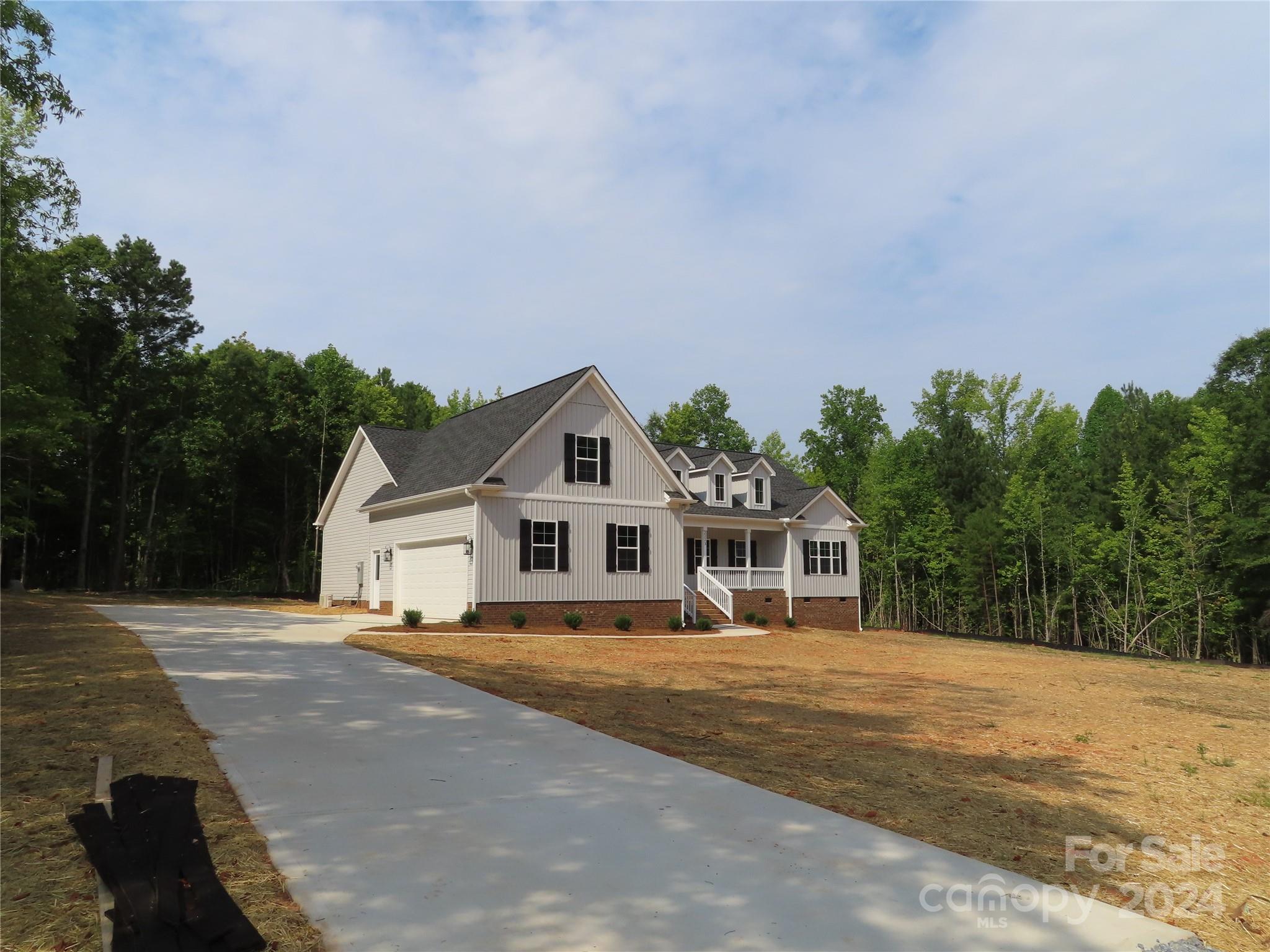 a front view of a house with a yard and trees