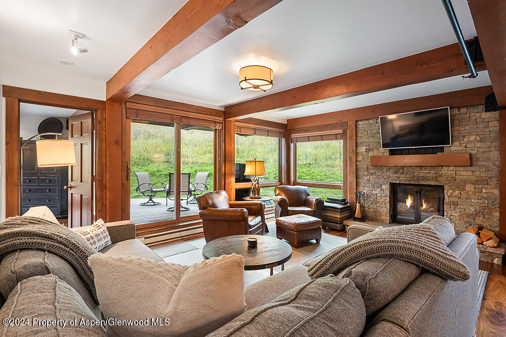 a living room with fireplace furniture and a large window