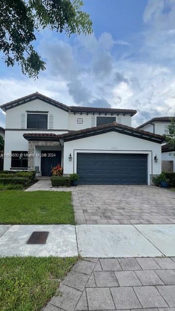 a front view of a house with a yard and a garage