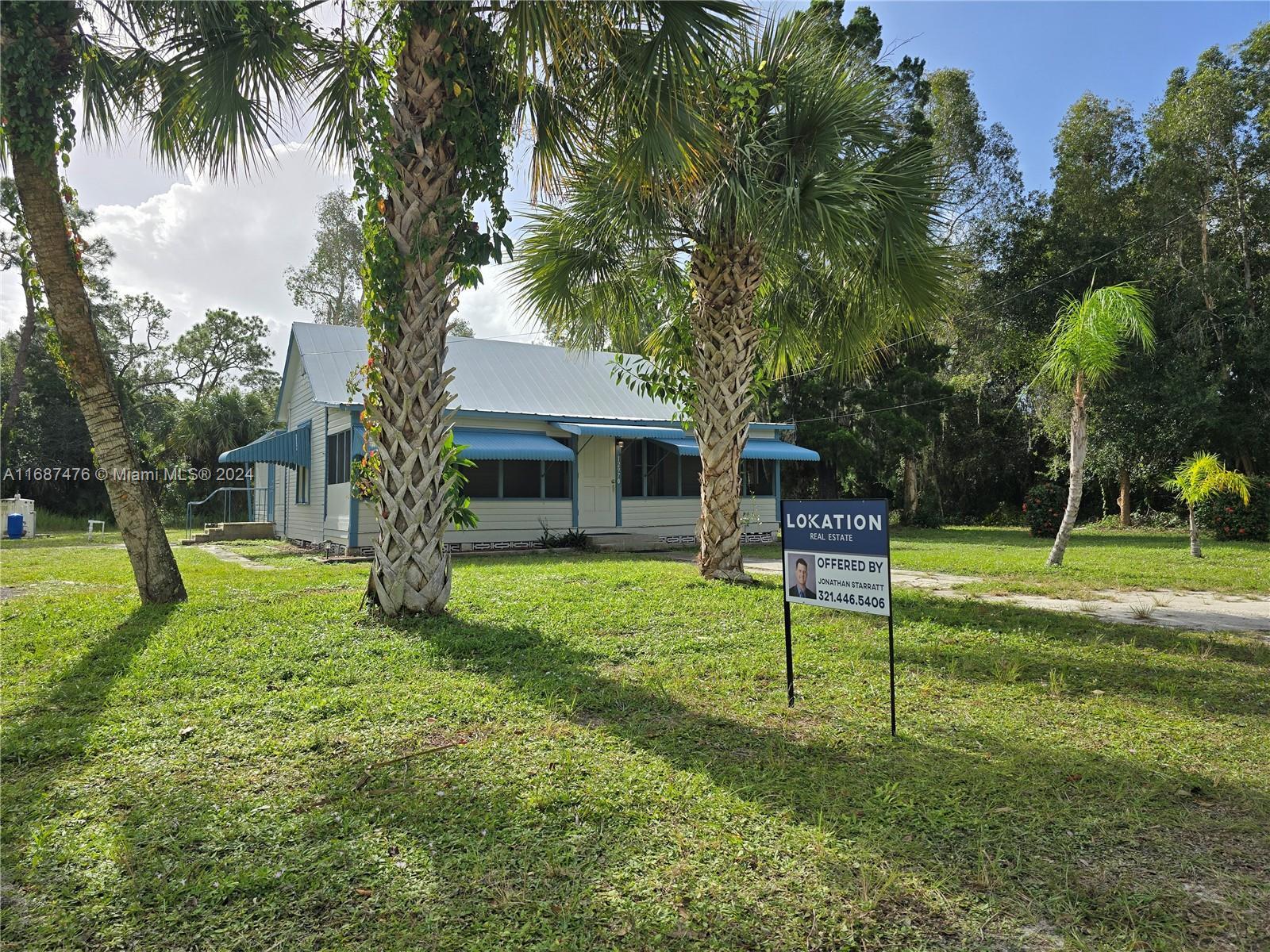 a view of a house with a backyard and a tree