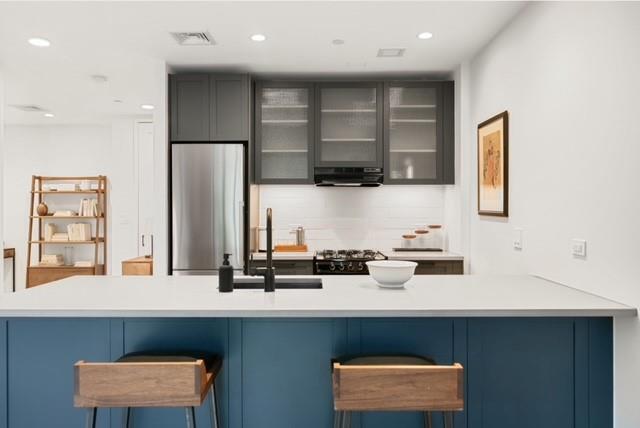 a kitchen with stainless steel appliances a sink cabinets and wooden floor