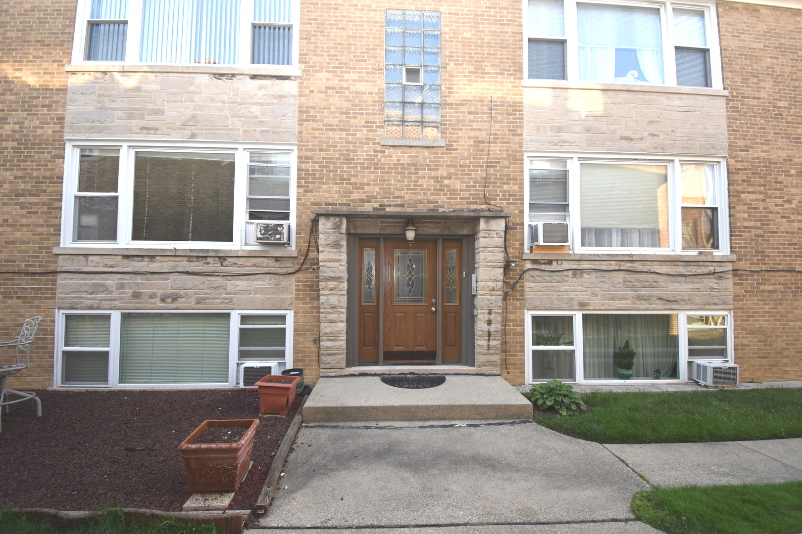 front view of a brick house with a yard