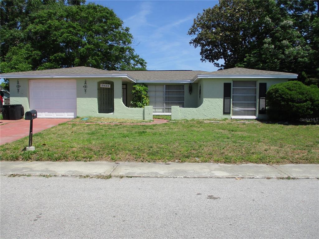 front view of a house with a yard and potted plants