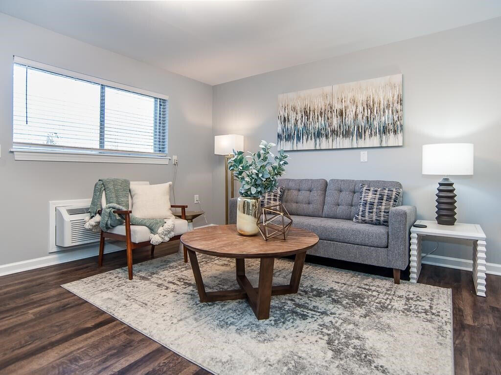 a living room with furniture a rug and a table