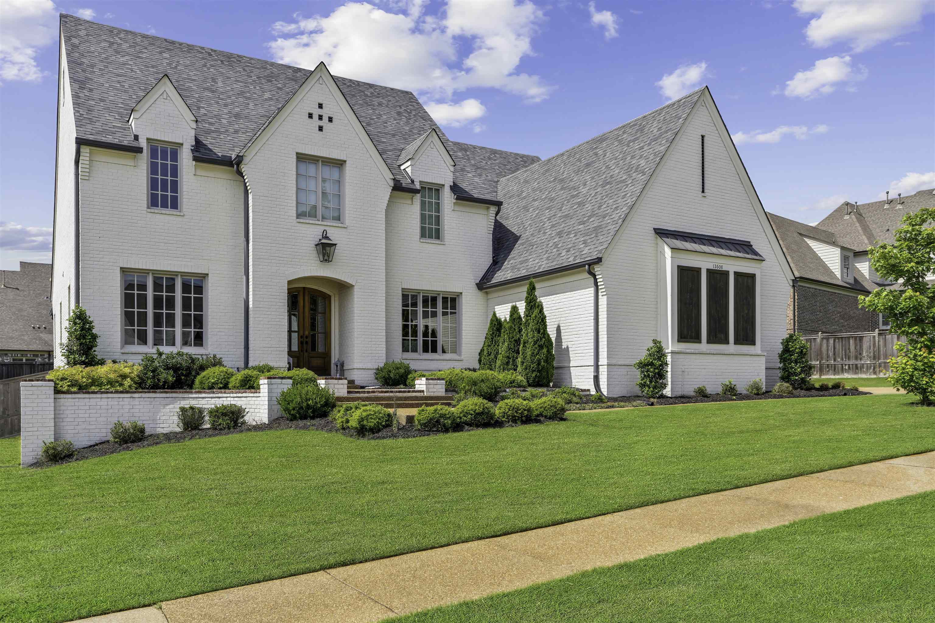 a front view of a house with a garden and plants