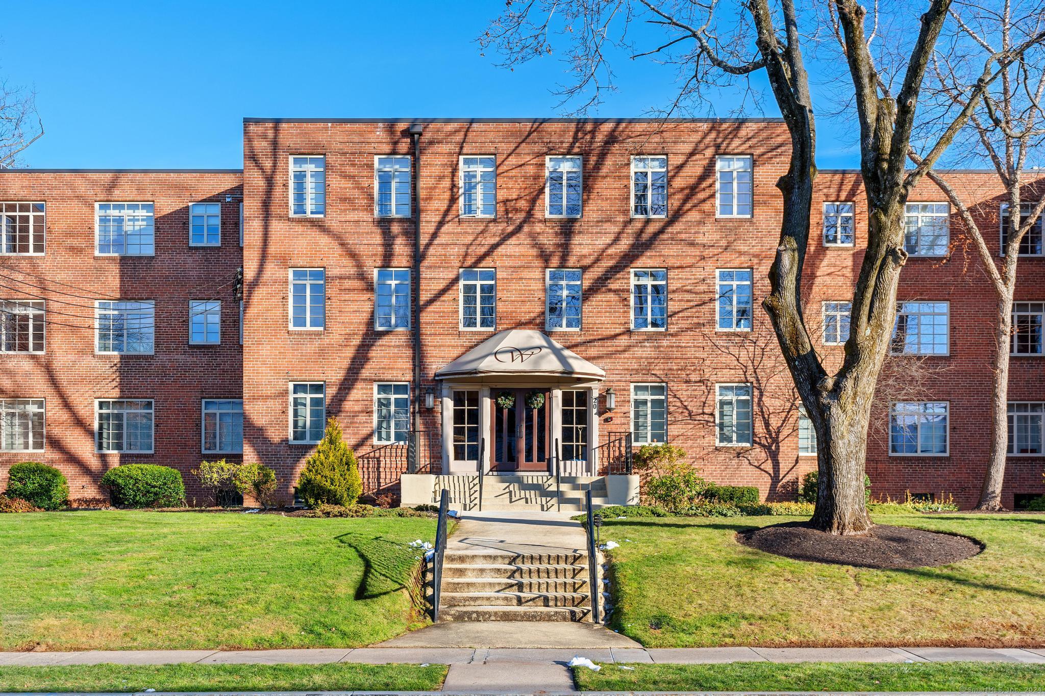 a front view of a residential apartment building with a yard