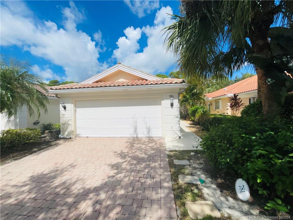 a front view of a house with a yard and a garage