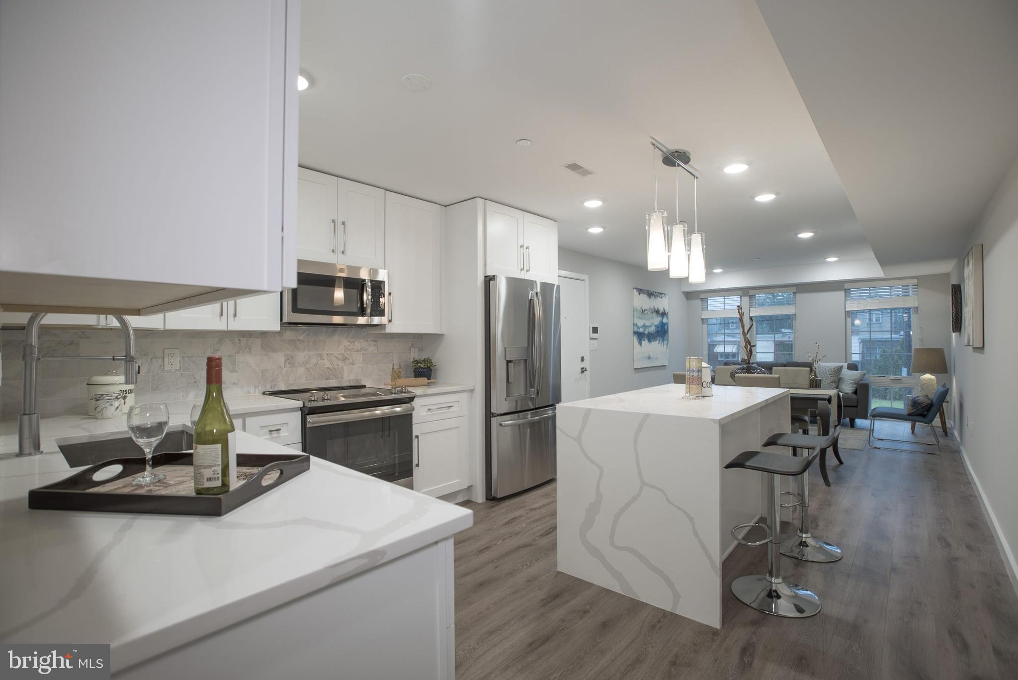 a kitchen that has a lot of counter space and stainless steel appliances