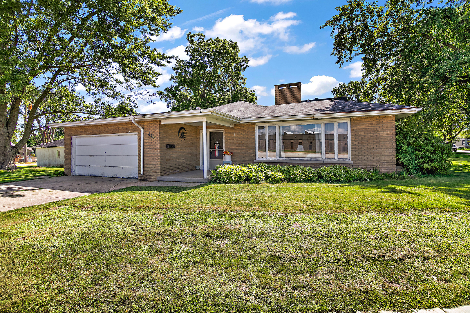 a front view of house with yard and trees around