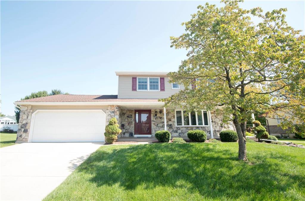 a front view of a house with a yard and a garage