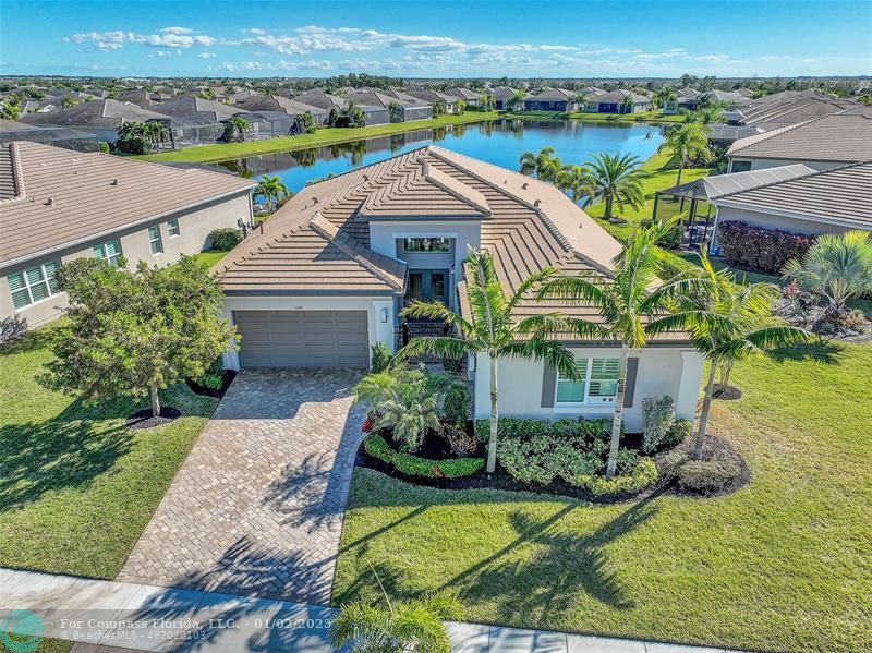 an aerial view of a house with a garden and lake view