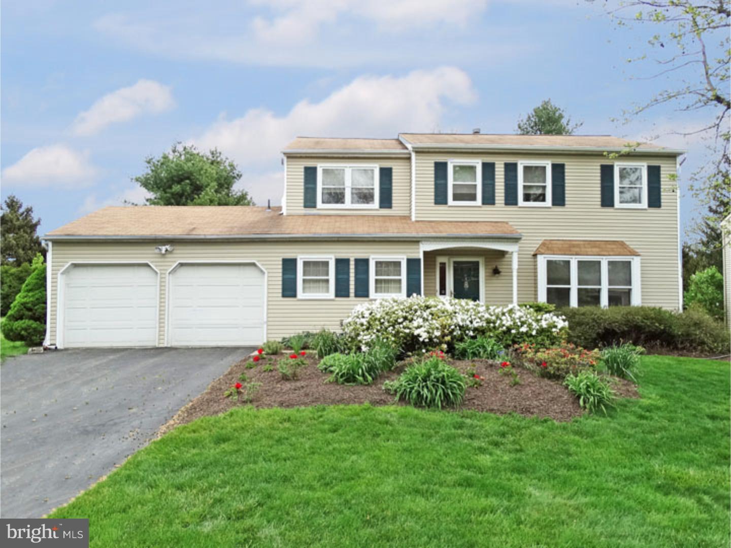 a front view of a house with a garden and yard