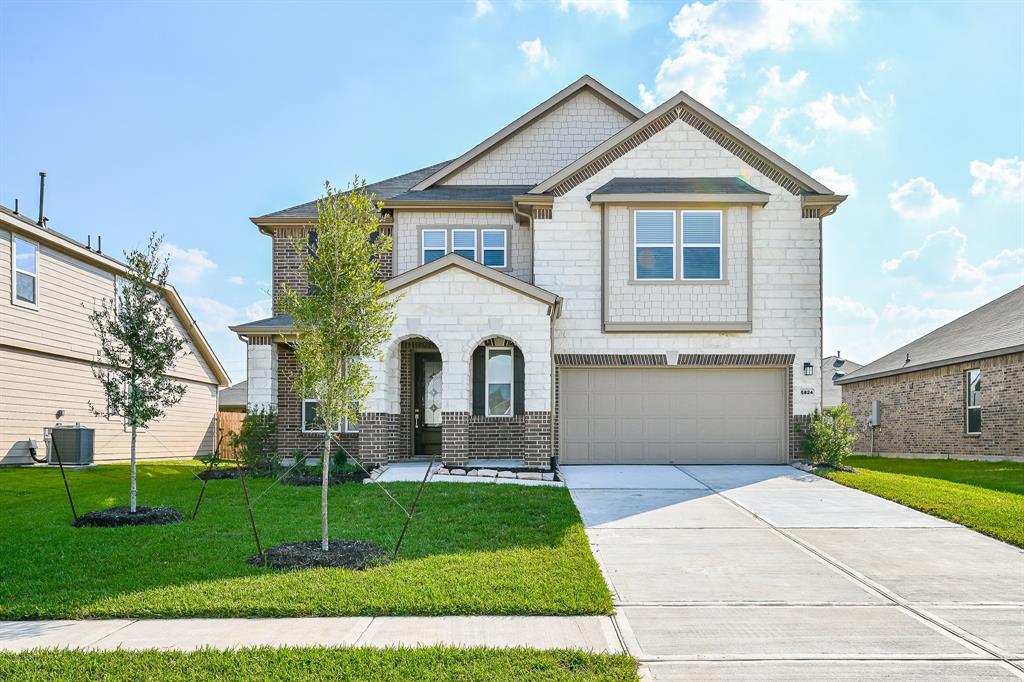 a front view of a house with a yard and garage