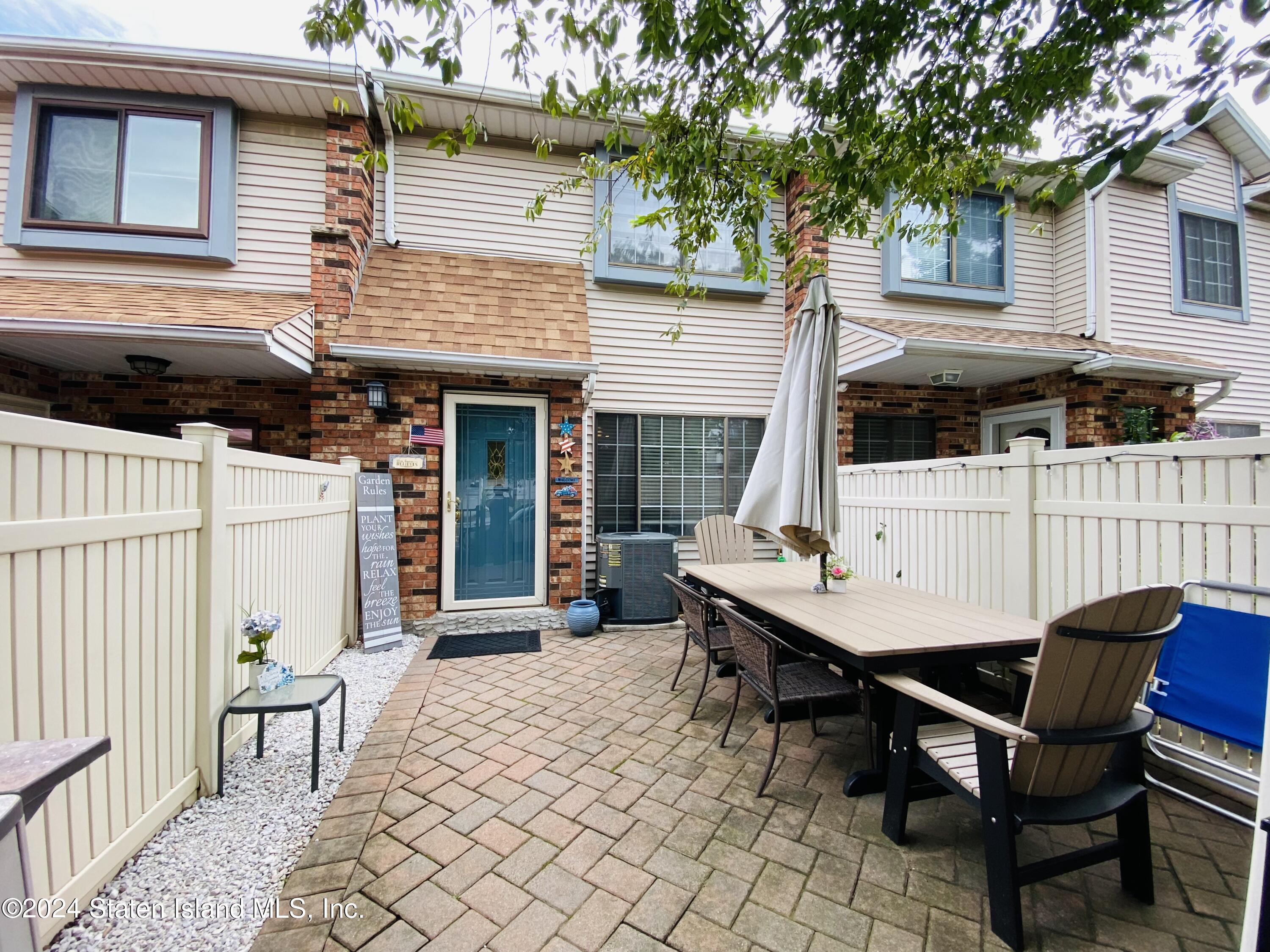 a backyard of a house with barbeque oven table and chairs