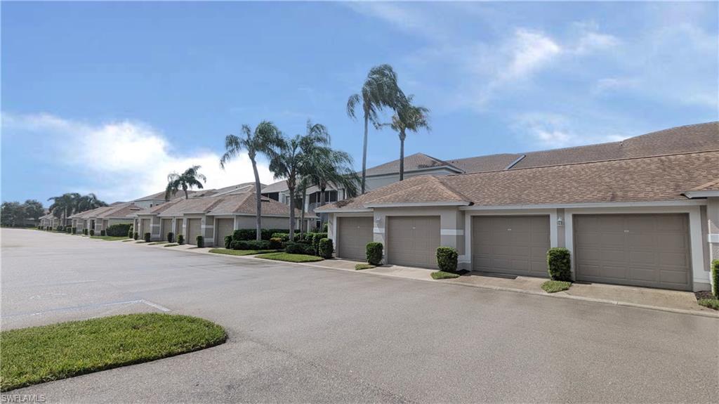 a view of a house with a yard and palm trees