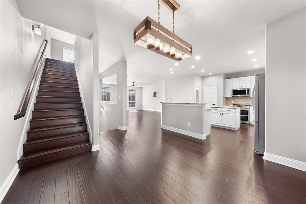 a view of a kitchen with wooden floors and stainless steel appliances