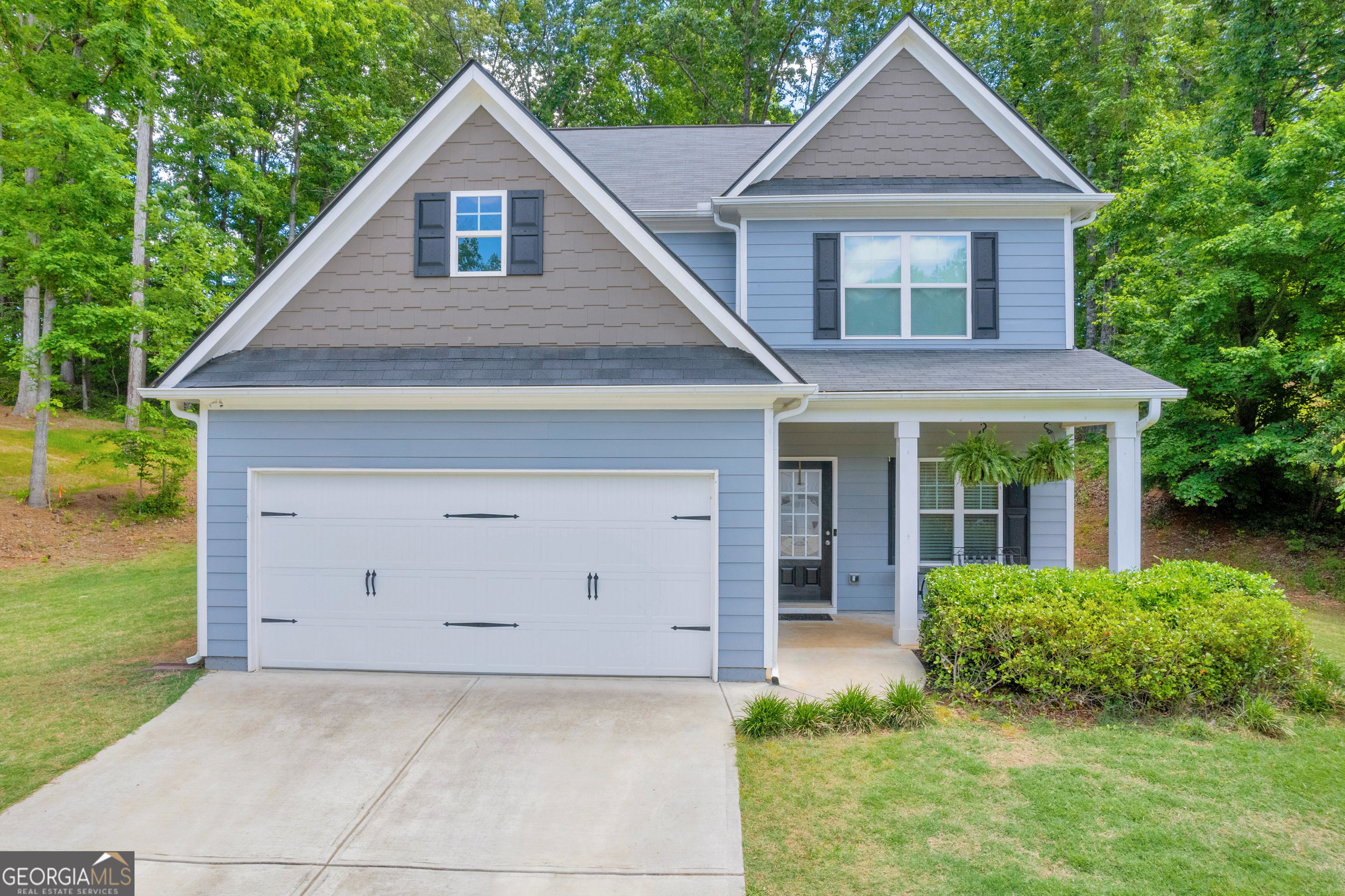 a front view of a house with a yard and trees