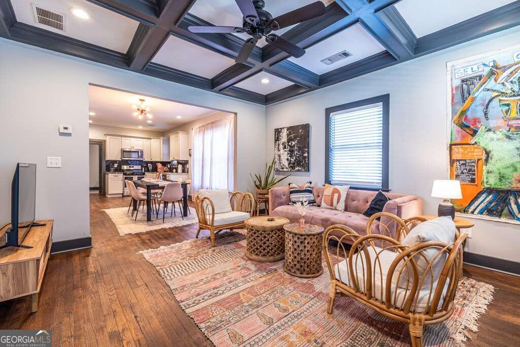 a living room with furniture appliances and a wooden floor