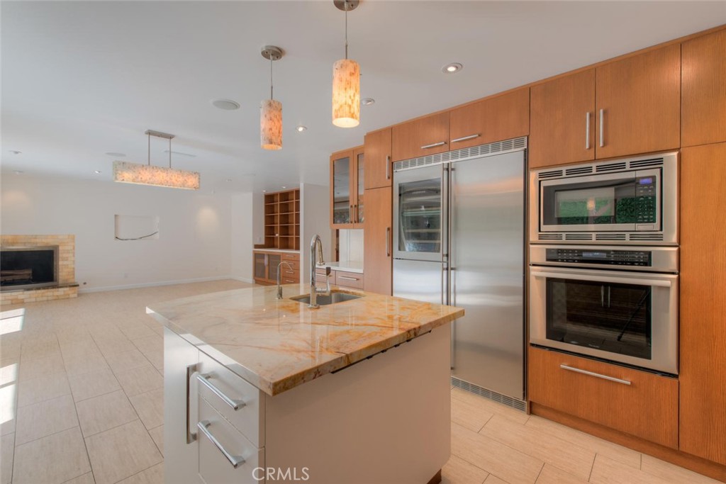 a kitchen with stainless steel appliances granite countertop a sink and a refrigerator