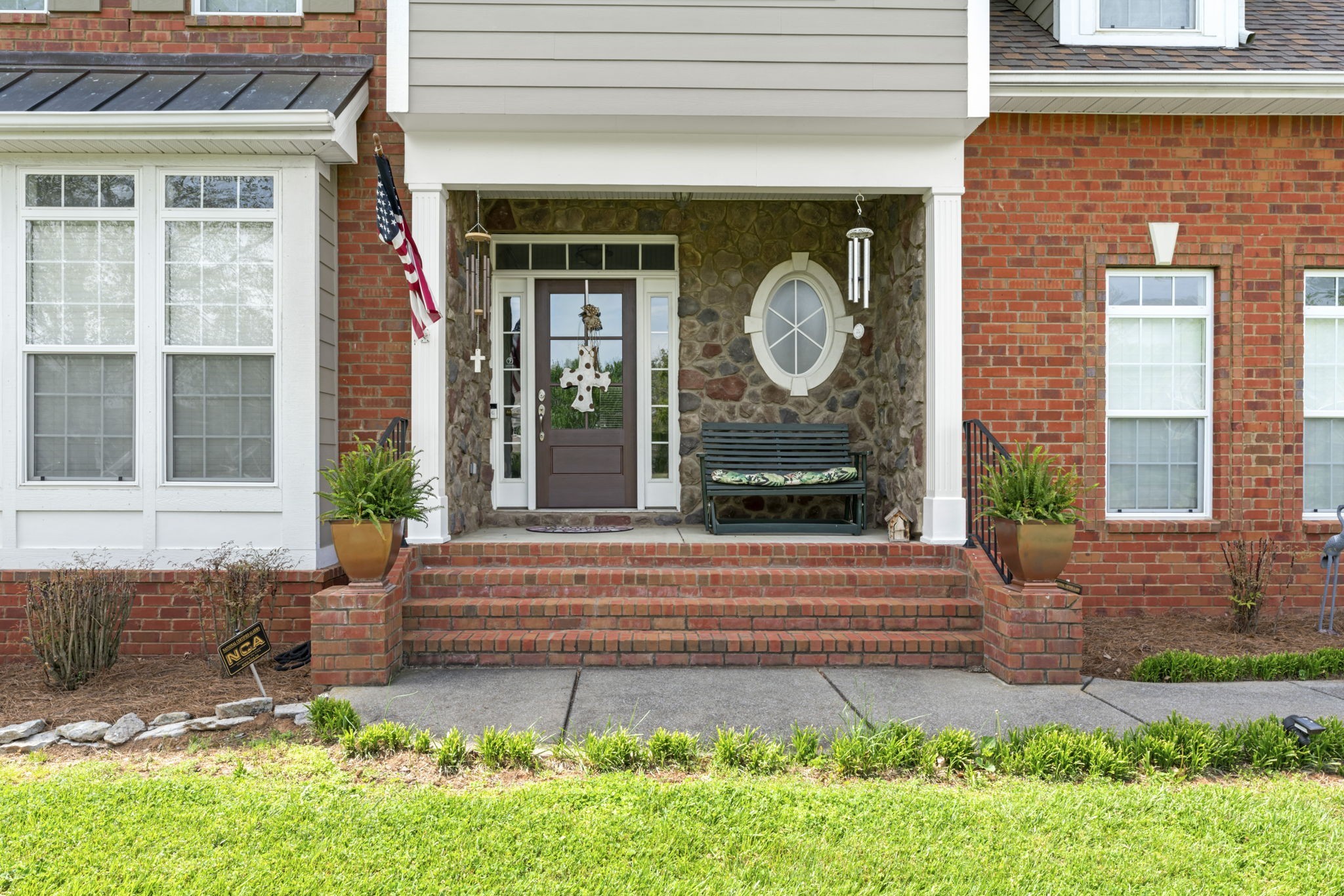 a front view of a house with garden and plants