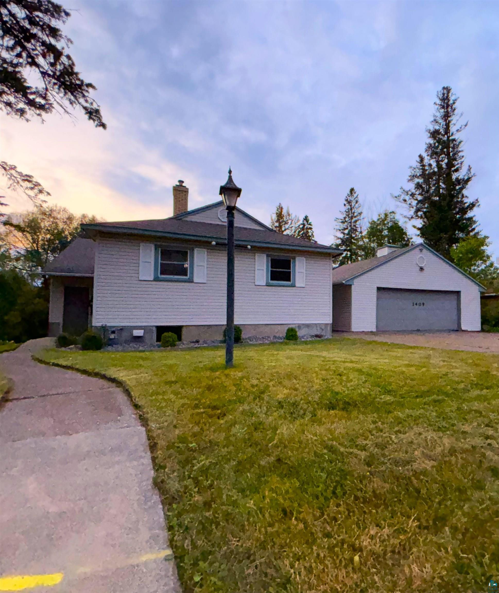 View of front of home featuring a garage and a yard