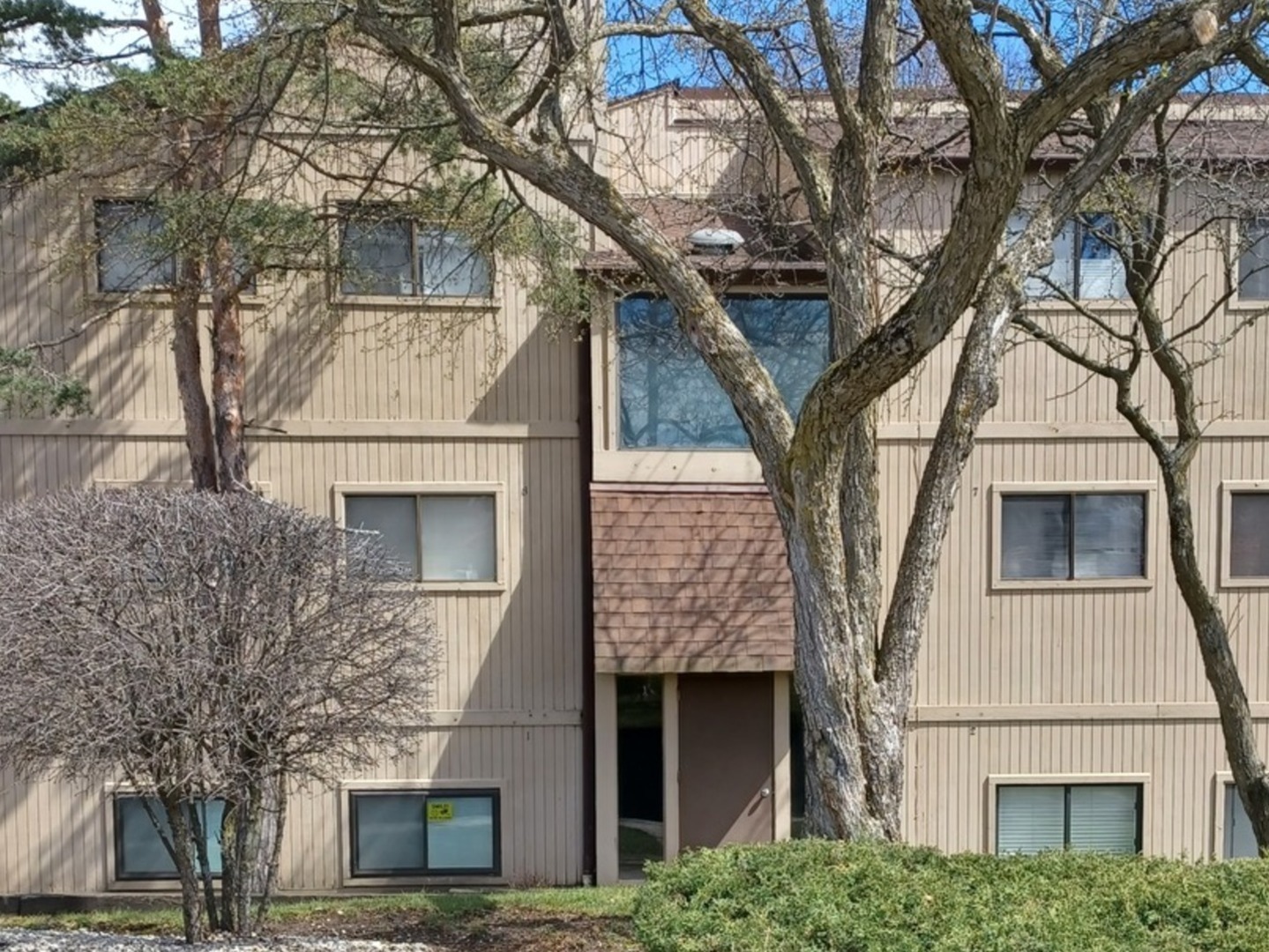 a front view of a house with a tree