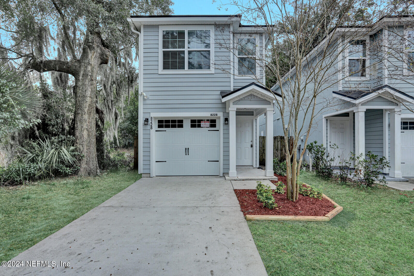 a front view of a house with a yard and trees