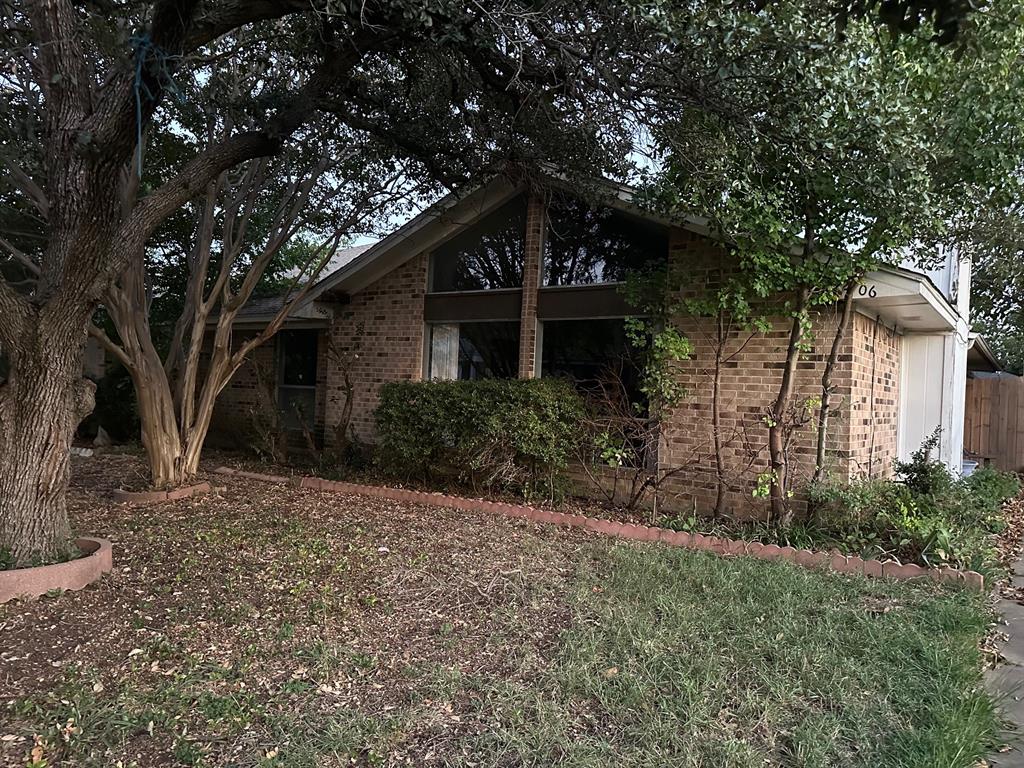 a front view of a house with a tree