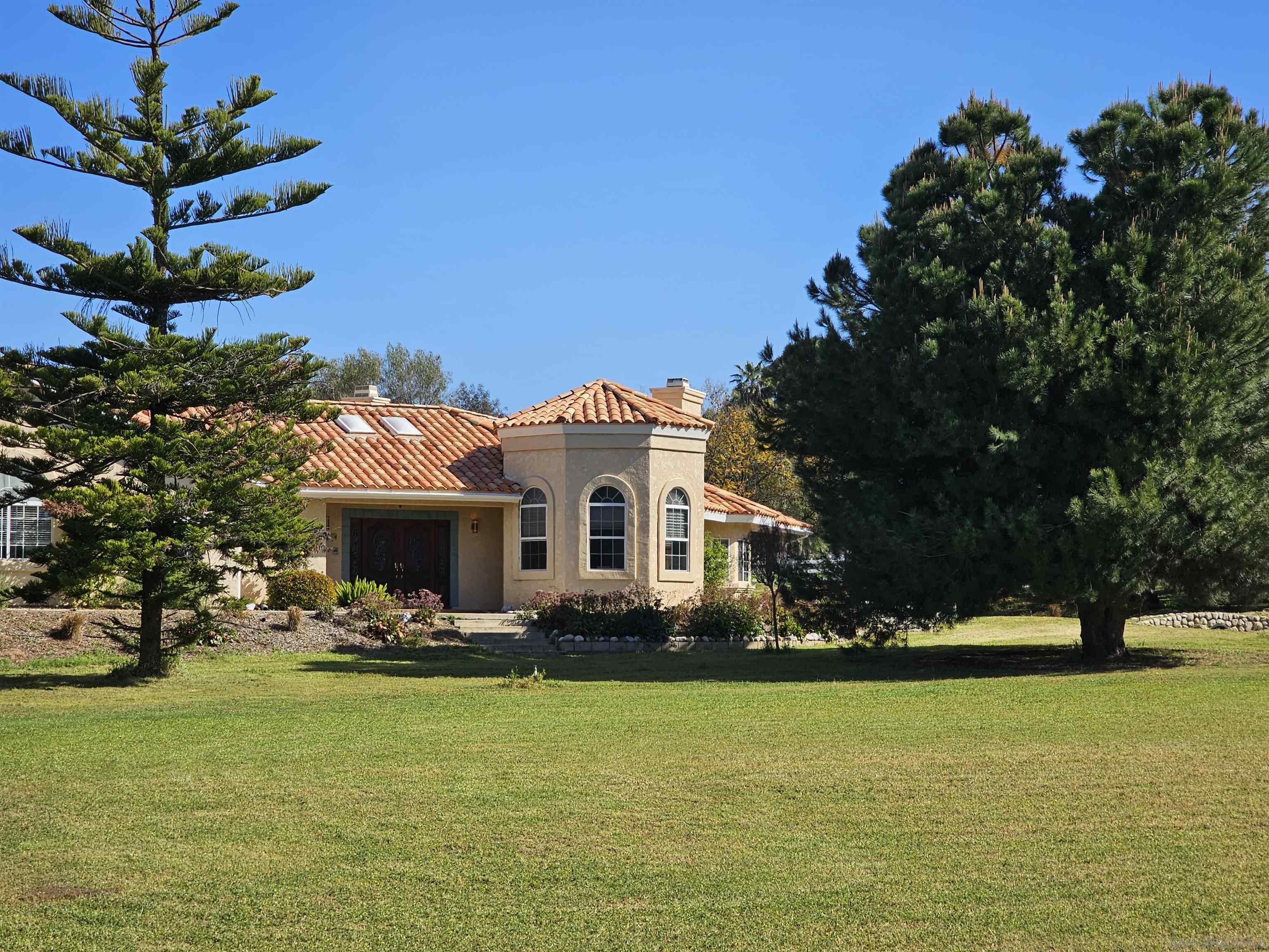 a front view of a house with a big yard