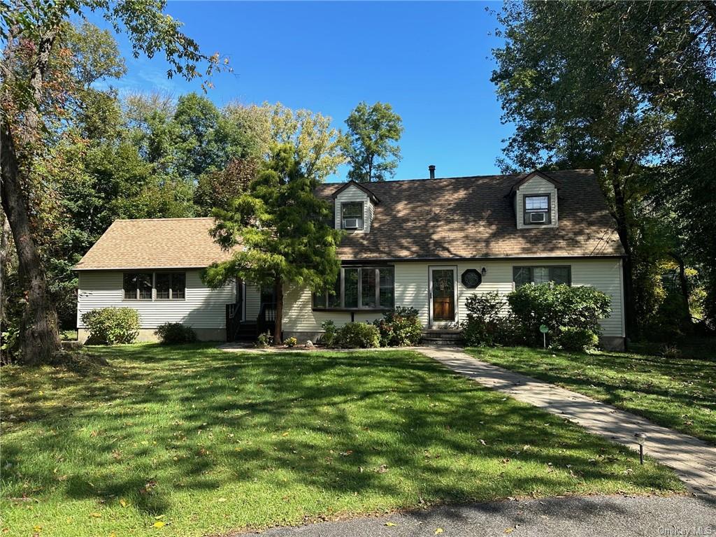 Cape cod home featuring a front yard