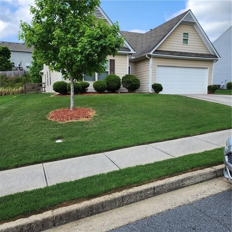 a front view of a house with a yard and potted plants