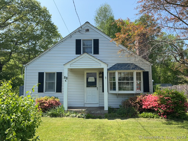 a front view of house with yard and trees around