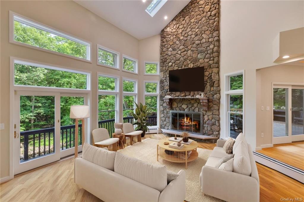 a living room with fireplace furniture and a large window