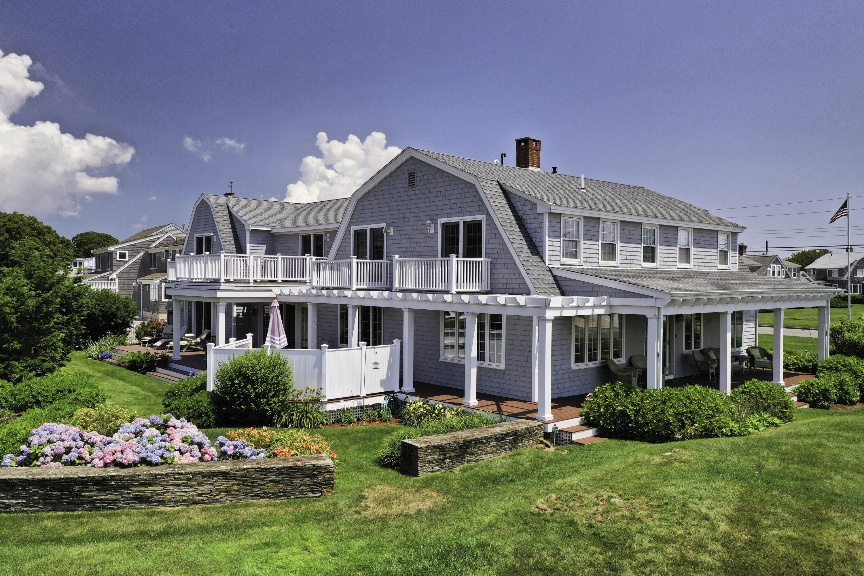 a front view of a house with a yard and potted plants