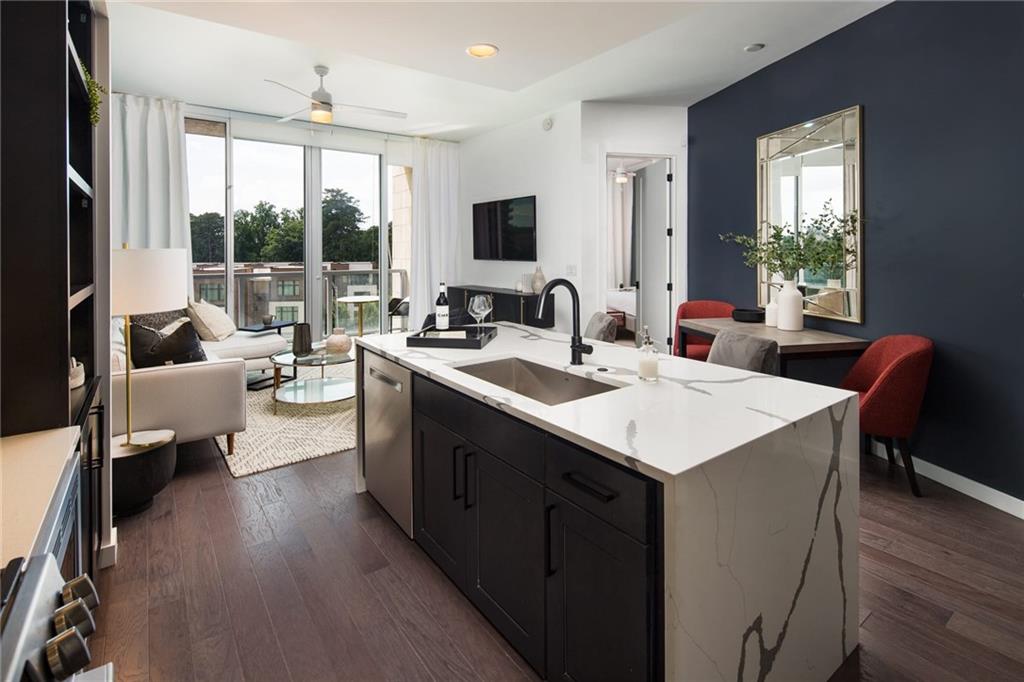 a large kitchen with sink a counter top space and living room