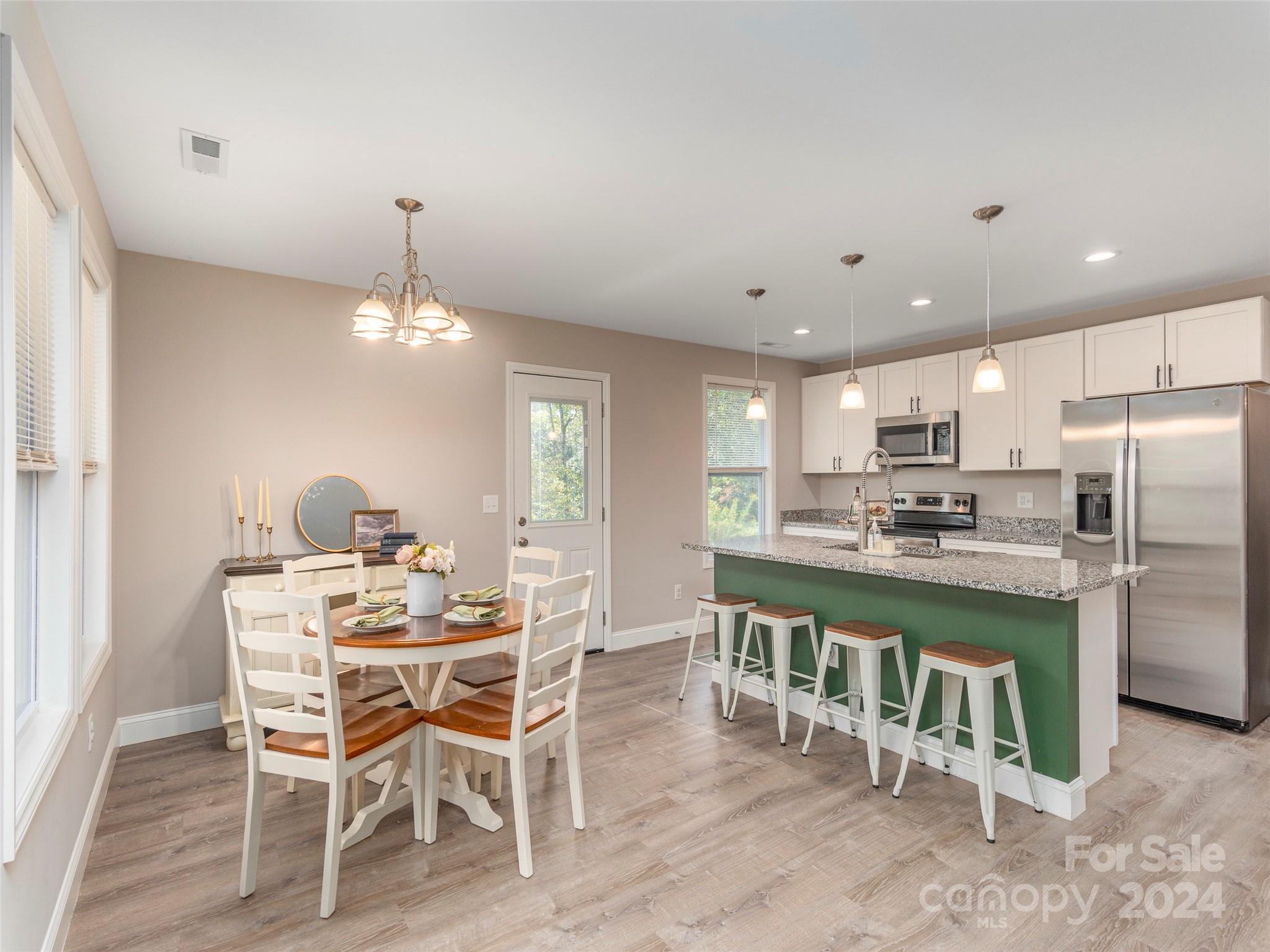 a dining area with a table chairs and a refrigerator