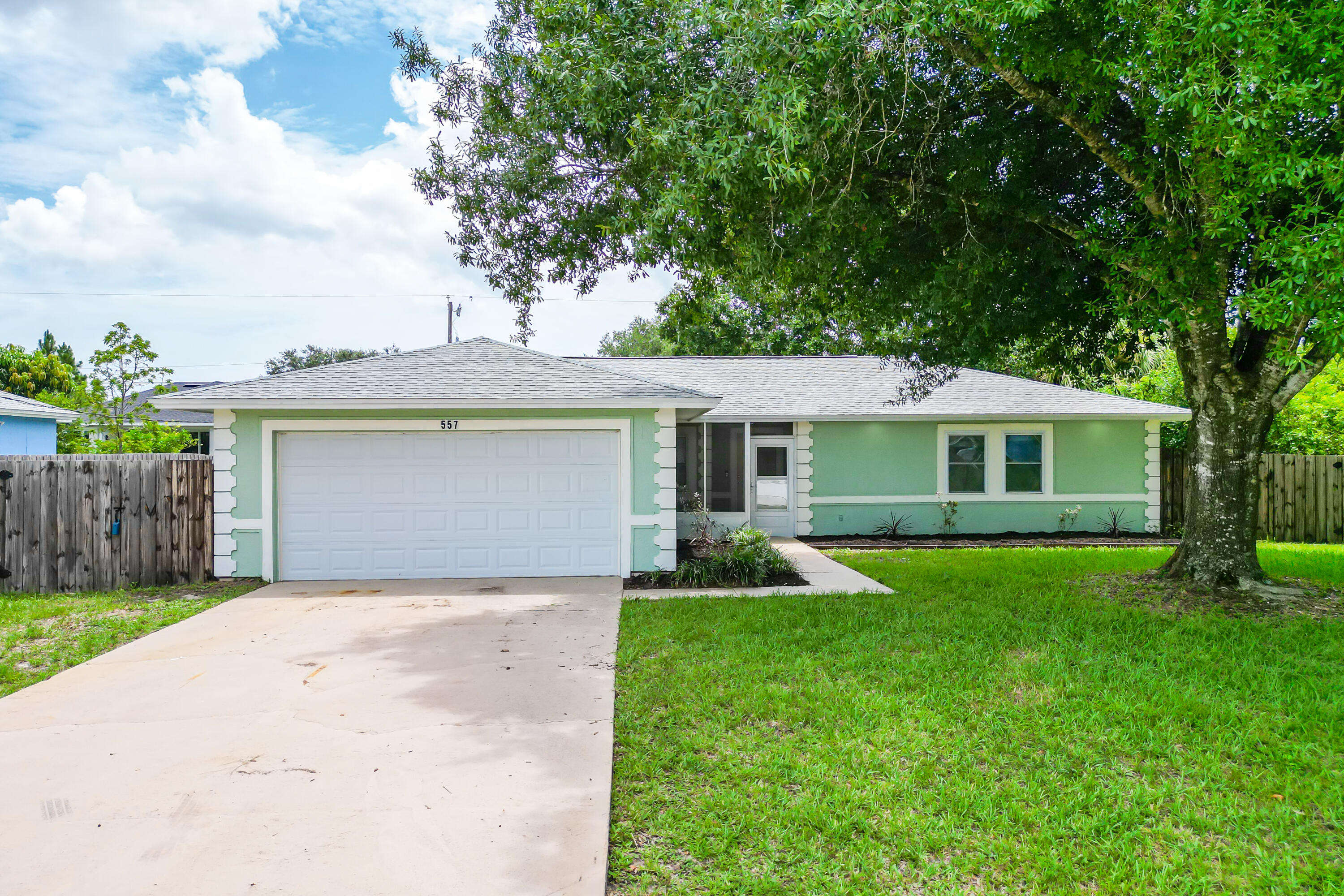 a front view of a house with yard and green space