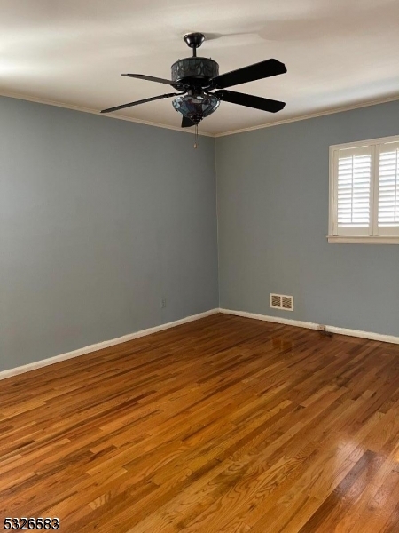 a view of a room with wooden floor cabinets and a ceiling fan