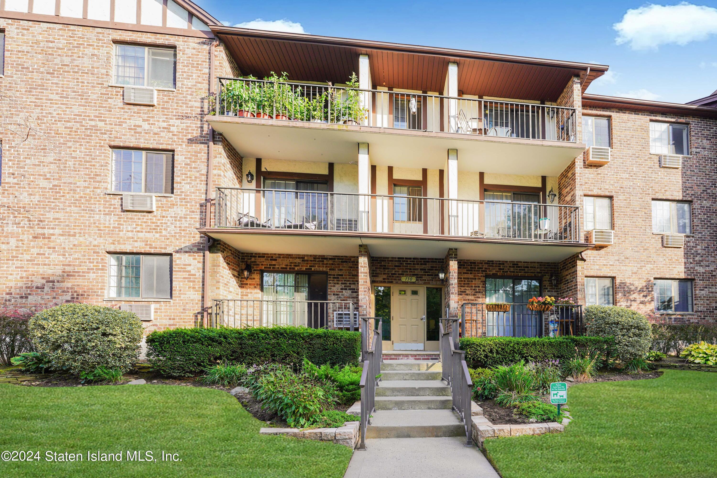 a front view of a residential apartment building with a yard