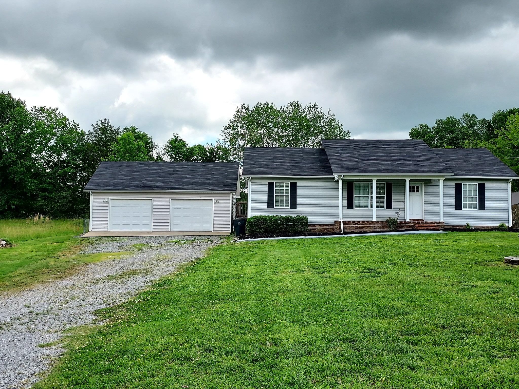 a front view of a house with yard and green space