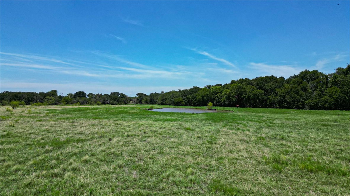 a view of a green field with wooden fence